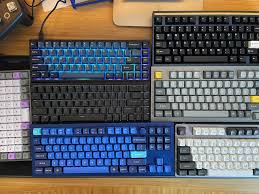 A variety of mechanical and backlit keyboards arranged on a desk, showcasing different layouts, switch types, and colors—ideal for exploring the top keyboards for programmers in 2025.