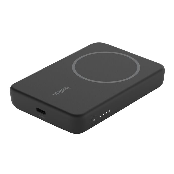 A rectangular, black Belkin magnetic wireless power bank with a circular charging pad on top, a USB-C port on the side, and four small LED indicator lights.