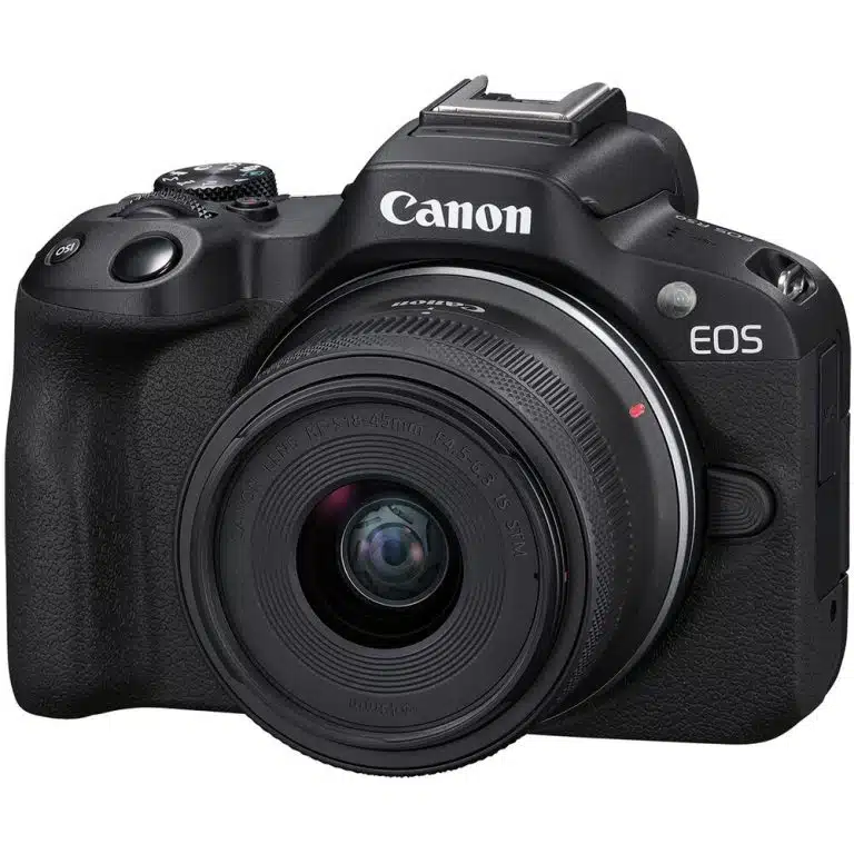 A three-quarter view of a black Canon EOS R50 mirrorless camera with an 18-45mm kit lens attached.