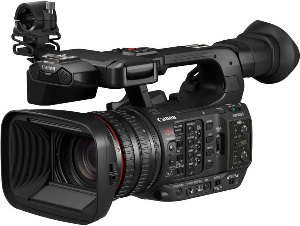 Professional Canon XF605 4K UHD camcorder with an integrated lens, multiple control buttons and dials, a top handle with XLR audio inputs, and a large eyepiece viewfinder, designed for broadcast-quality video production.