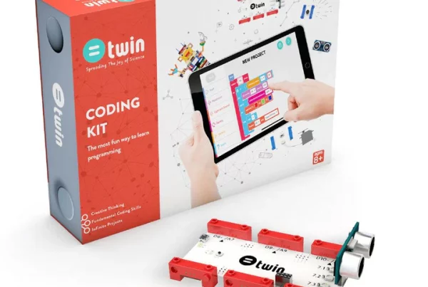 A "Twin Science Coding Kit" is displayed in an eye-level, slightly angled shot against a white background. The kit includes a large white box with a colorful graphic of hands interacting with a tablet displaying a block-based coding interface, and a smaller, red rectangular box nested within the larger one. The red box is labeled "@twin Coding Kit: The most fun way to learn programming," and lists "Creative Thinking," "Fundamental Coding Skills," and "Infinite Projects." In the foreground, a white circuit board with red connectors and two ultrasonic sensors is visible. The large white box also has an "AGES 8+" label.