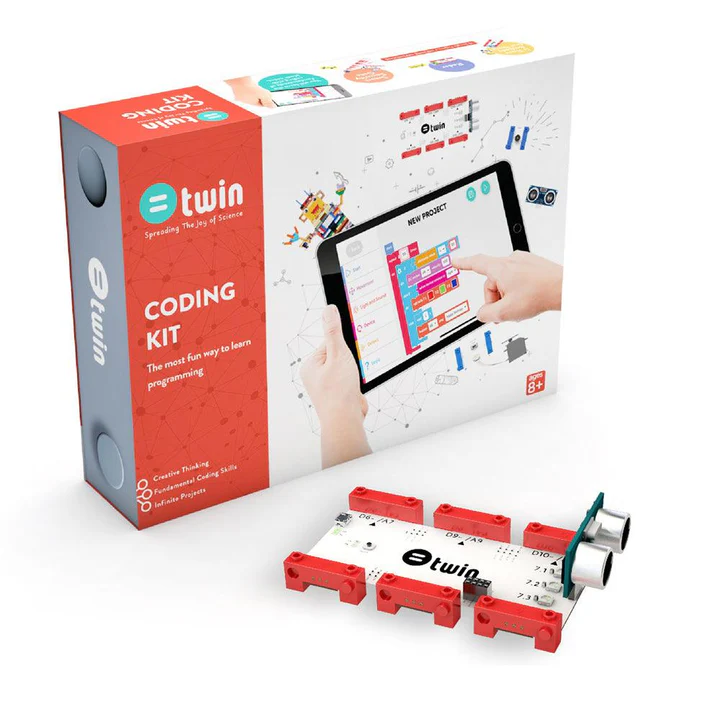 A "Twin Science Coding Kit" is displayed in an eye-level, slightly angled shot against a white background. The kit includes a large white box with a colorful graphic of hands interacting with a tablet displaying a block-based coding interface, and a smaller, red rectangular box nested within the larger one. The red box is labeled "@twin Coding Kit: The most fun way to learn programming," and lists "Creative Thinking," "Fundamental Coding Skills," and "Infinite Projects." In the foreground, a white circuit board with red connectors and two ultrasonic sensors is visible. The large white box also has an "AGES 8+" label.