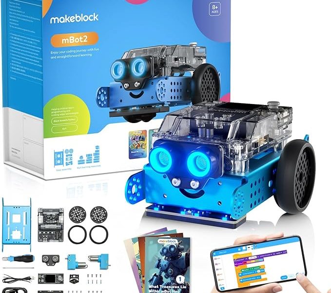 A blue makeblock mBot2 robot kit is displayed against a white background, accompanied by its packaging and various components. The assembled blue robot, with clear top casing and two large glowing blue "eyes," is prominent in the foreground. Behind it is the white and blue retail box, which features an image of the robot and details like "mBot2" and "Enjoy your coding journey with fun and straightforward learning." In the bottom left, an array of disassembled robot parts, including blue metal plates, wheels, and circuit boards, are laid out. Below the robot in the foreground, a smartphone screen shows a colorful coding interface, with a hand pointing to it. To the left of the phone, an instruction booklet with a robot illustration on its cover is also visible.