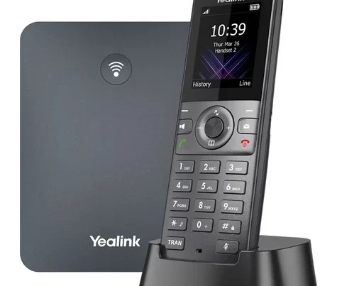 A Yealink W71P DECT IP phone system with a dark grey base station featuring a Wi-Fi symbol and a black cordless handset in its charging cradle displaying the time, date, and "Handset 2".