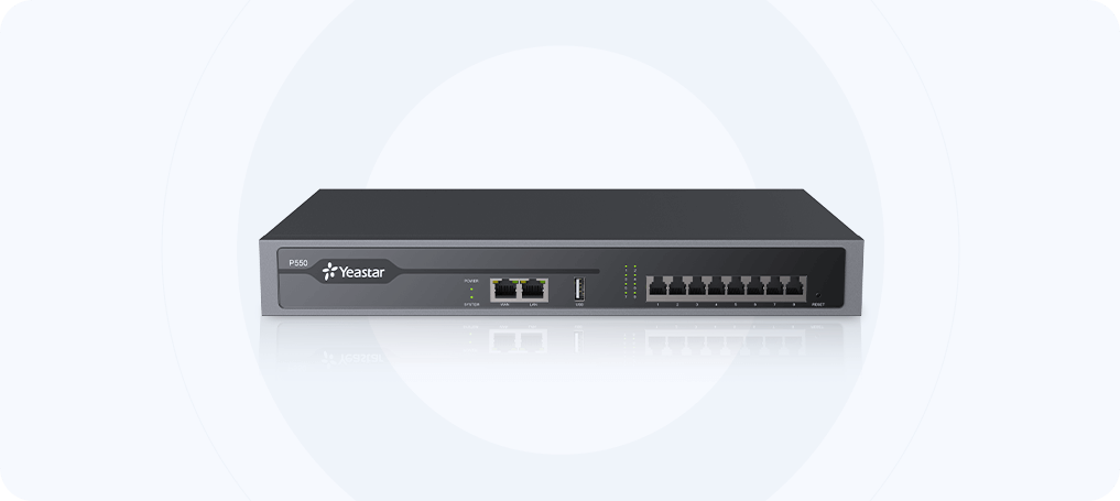 A dark gray rectangular Yeastar P550 IP PBX phone system sits on a white surface, with a light gray circular halo behind it. The front panel features a "P550" label and a "Yeastar" logo on the left. To the right are indicator lights for SYSTEM and POWER, followed by two Ethernet ports labeled WAN and LAN, and a USB port. Further to the right are eight numbered ports, and on the far right, a small RESET button.