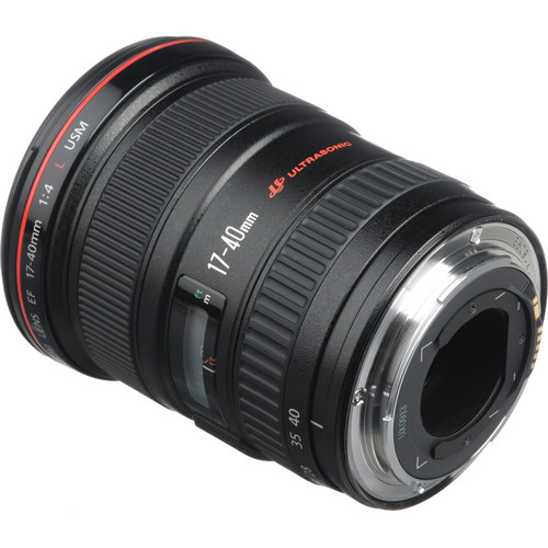 A studio shot of a black Canon EF 17-40mm f/4L USM lens. The lens is positioned at a three-quarter angle, showing both the front element and the silver EF mount at the rear. The red ring, a hallmark of Canon's L-series lenses, is visible near the top.
