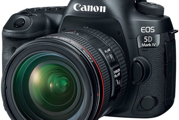A professional product shot of a black Canon EOS 5D Mark IV DSLR camera with a Canon zoom lens attached. The camera is angled slightly to the right, showcasing the front of the lens and the body with "Canon" and "EOS 5D Mark IV" branding. The background is a solid white.