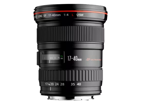 A product shot of a black Canon EF 17-40mm f/4L USM lens, standing upright on a black background. The red ring, a key feature of Canon's professional-grade L-series lenses, is clearly visible near the top of the lens. The focus distance window and zoom markings are also prominent.